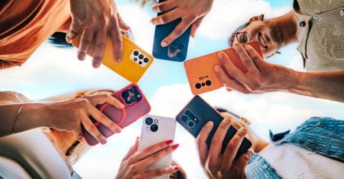 Group of young people using smartphones outside. (Shutterstock Photo)