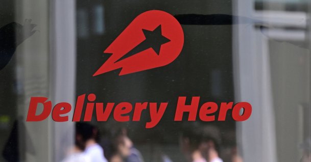 People are reflected in a window with the company logo at the headquarters of German food delivery group Delivery Hero, Berlin, Germany, July 16, 2026. (AFP Photo)