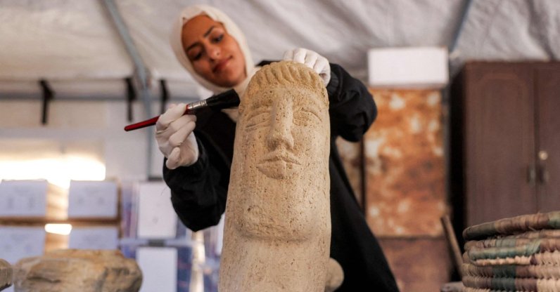 A staffer from the Mayasem Association for Culture and Arts brushes an artefact as others repair and scientifically-restore a number of artefacts collected during the war in Gaza, at the cultural heritage storage facility, currently based in a tent in Khan Younis, southern Gaza, Palestine, July 11, 2026. (AFP Photo)