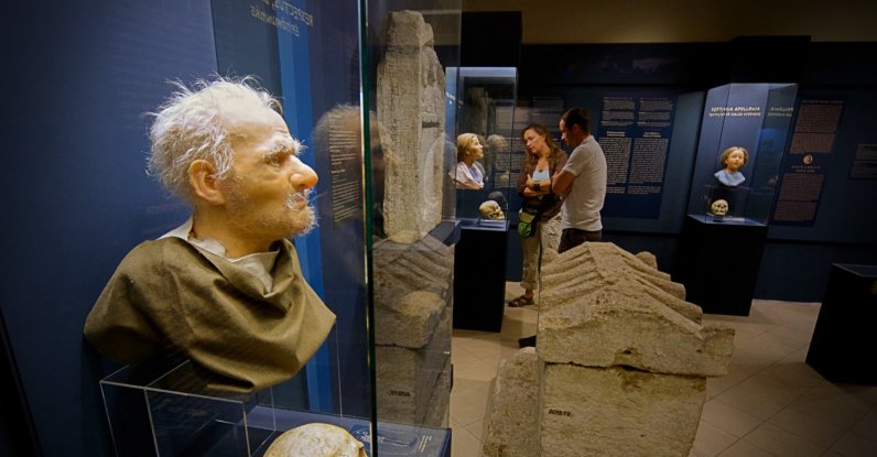 Visitors look at Roman-era skulls and their facial reconstructions in the Aquincum Museum's exhibition, Budapest, Hungary, July 7, 2026. (AP Photo)