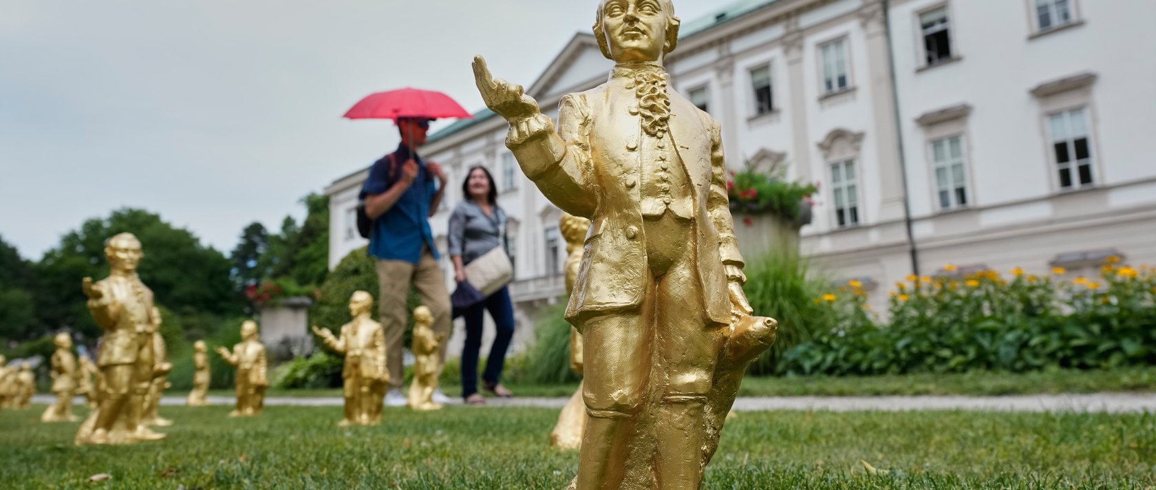 People pass 300 gold colored plastic Mozart sculptures by German artist Ottmar Hoerl from Nuremberg before the 270th birthday of composer Wolfgang Amadeus Mozart, Salzburg, Austria, July 15, 2026. (AP Photo)