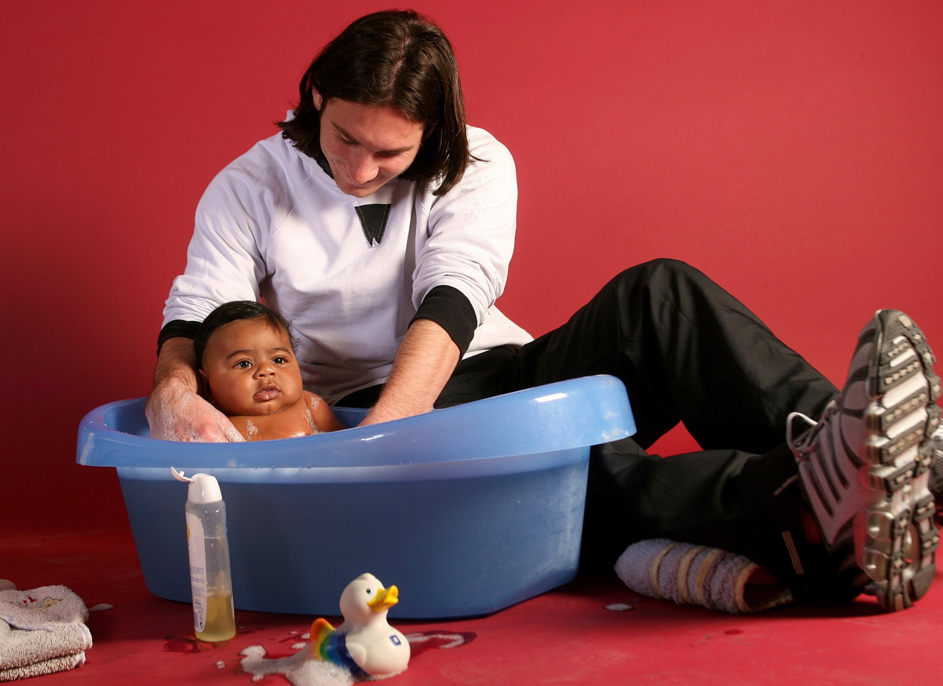 20-year-old Lionel Messi helping to bathe 6-month-old Lamine Yamal during a photo session in the dressing room of the Camp Nou stadium, Barcelona, Spain, Oct. 31, 2007. (AP Photo)