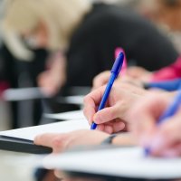 A university student takes an exam in a classroom. (Shutterstock Photo)