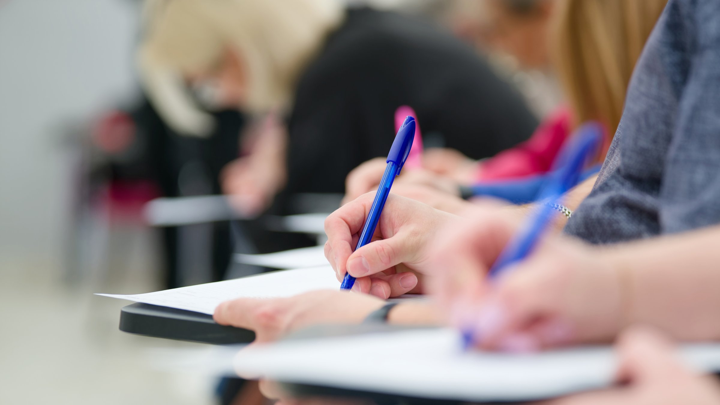 A university student takes an exam in a classroom. (Shutterstock Photo)