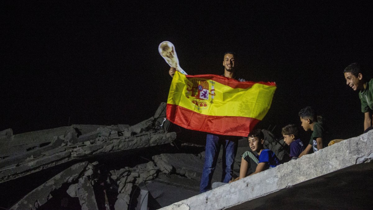 A Palestinian football fan holds a Spain flag while watching the 2026 FIFA World Cup final match between Argentina and Spain, in the al-Faluja area, north of Jabalia, northern Gaza Strip, Palestine, July 19, 2026. (EPA Photo)
