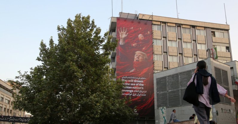 People walk in front of a huge anti-U.S. and anti-Israel billboard in Tehran, Iran, July 19, 2026. (AA Photo)