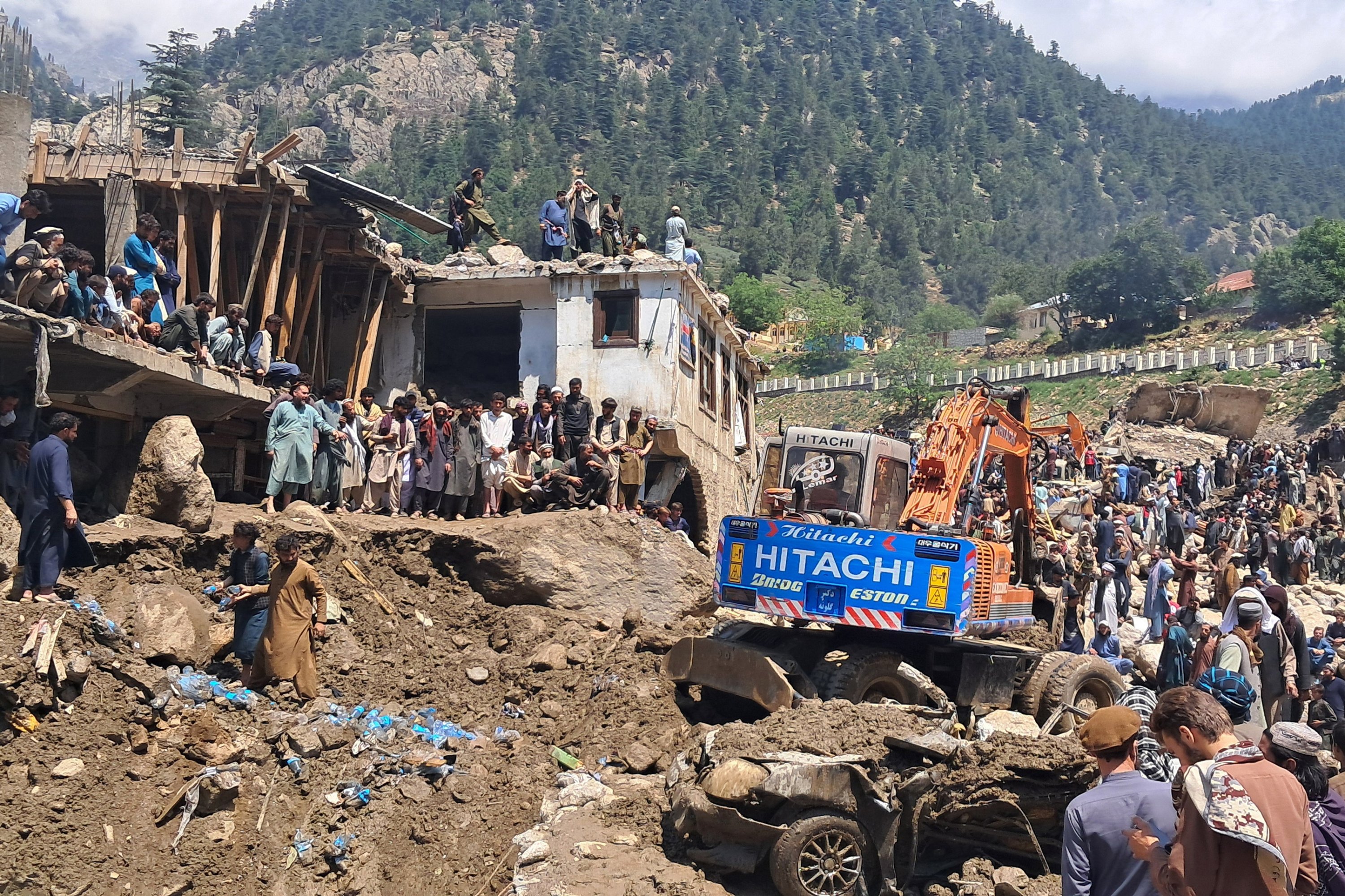 Residents and rescue workers gather to clear debris and inspect the damage following flash floods in Parun, Nuristan province, eastern Afghanistan, July 21, 2026. (EPA Photo)