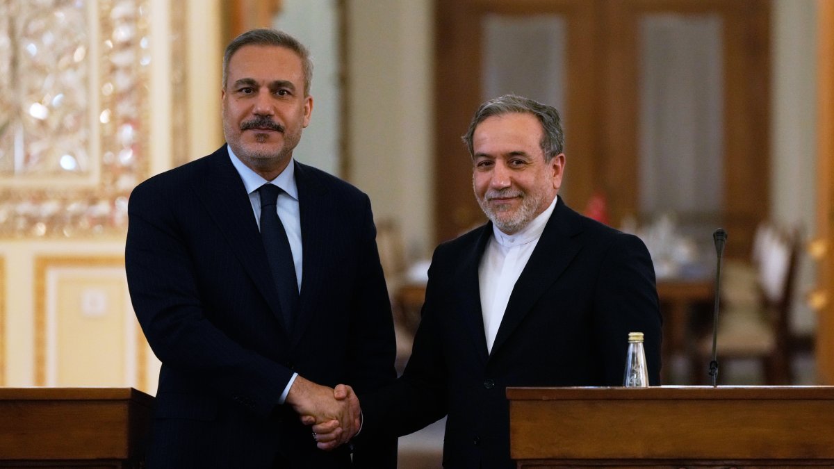 Foreign Minister Hakan Fidan (L) and his Iranian counterpart Abbas Araghchi shake hands at the conclusion of their joint news briefing after their meeting, Tehran, Iran, Nov. 30, 2025. (AP Photo)