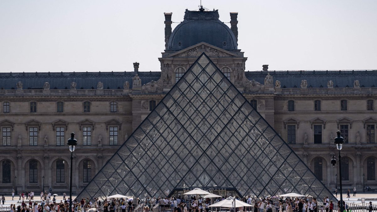 Tourists walk past the Louvre Museum and the Pyramide du Louvre, central Paris, France, July 18, 2026. (AFP Photo)