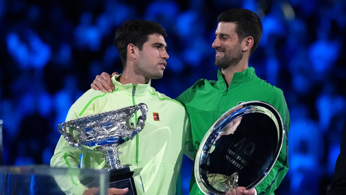 Spain's Carlos Alcaraz (L) holds the Norman Brookes Challenge Cup after defeating Serbia's Novak Djokovic in the men's singles final at the Australian Open tennis championship, Melbourne, Australia, Feb. 1, 2026. (AP Photo)