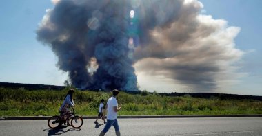 Local residents walk past the smoke of a fire at the Russian e-commerce firm Wildberries' logistics complexes, town of Elektrostal, outside Moscow, Russia, July 18, 2026. (AFP Photo)
