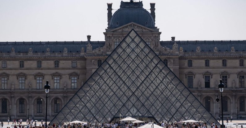 Tourists walk past the Louvre Museum and the Pyramide du Louvre, central Paris, France, July 18, 2026. (AFP Photo)