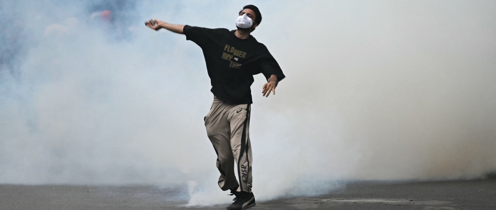 A protester throws back a tear gas canister fired by Rapid Action Force (RAF) personnel to disperse supporters of the Cockroach Janta Party (CJP), during a protest demanding the resignation of India's Education Minister Dharmendra Pradhan over alleged NEET exam irregularities in New Delhi, India, July 20, 2026. (AFP Photo)