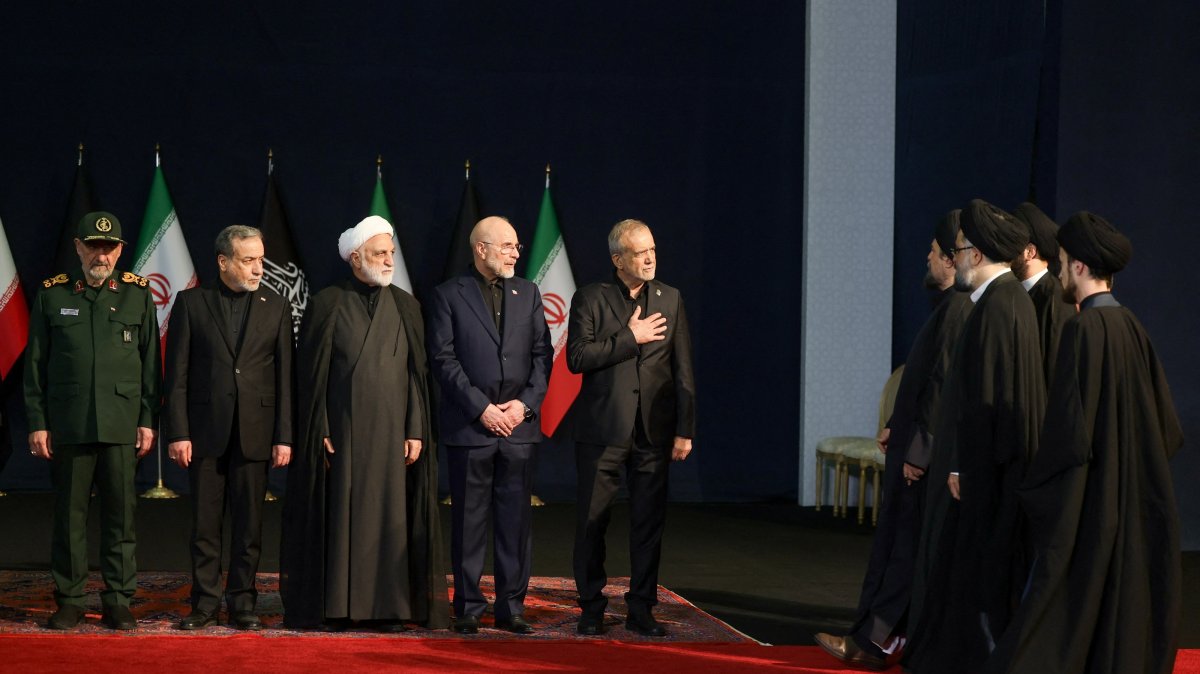 Iranian President Masoud Pezeshkian (C) gestures as he greets Hassan Khomeini, grandson of the first Iranian Supreme Leader Ruhollah Khomeini, as he, Iranian military commander Mohsen Rezaee (1st-L), Iranian Foreign Minister Abbas Araqchi (2nd-L), Chief Justice of Iran Gholam-Hossein Mohseni Ejei (3rd-L) and Iran's parliament speaker Mohammad Baqer Qalibaf (4th-L) attend a farewell ceremony for Iran's late Supreme Leader Ali Khamenei, Tehran, Iran, July 3, 2026. (Reuters Photo)
