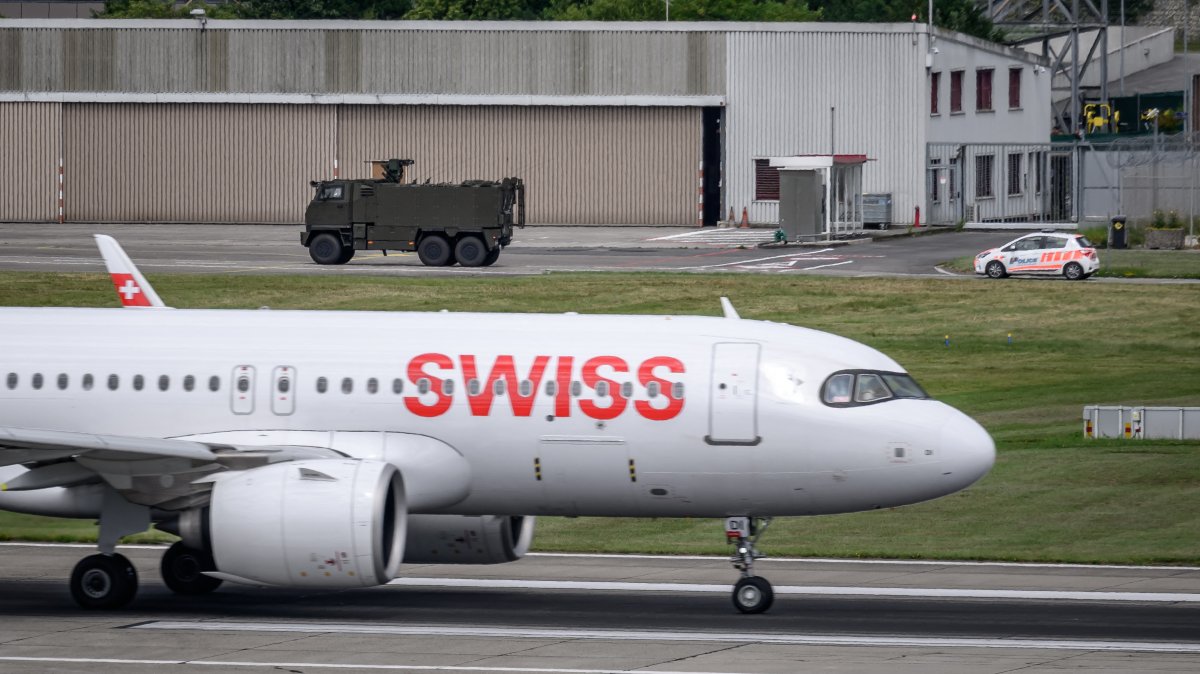 A Swiss Army vehicle and a police car pass behind the tail of a Swiss International Air Lines aircraft during a patrol on the tarmac at Geneva Airport ahead of the upcoming G7 summit in nearby Evian, in Geneva, June 11, 2026. (AFP File Photo)