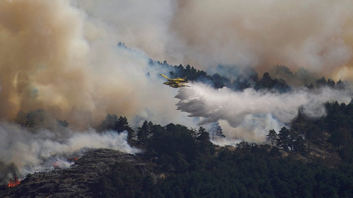An airplane releases water above the wildfire of La Mierla in Condemios de Arriba, Guadalajara, Spain, July 22, 2026. (Reuters Photo)