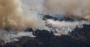An airplane releases water above the wildfire of La Mierla in Condemios de Arriba, Guadalajara, Spain, July 22, 2026. (Reuters Photo)