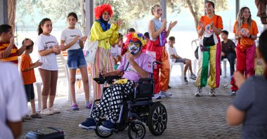 Fırat Arsunar, founder of the Volunteer Clowns Group, entertains children during a community outreach event in Adana, southern Türkiye, July 22, 2026. (AA Photo)