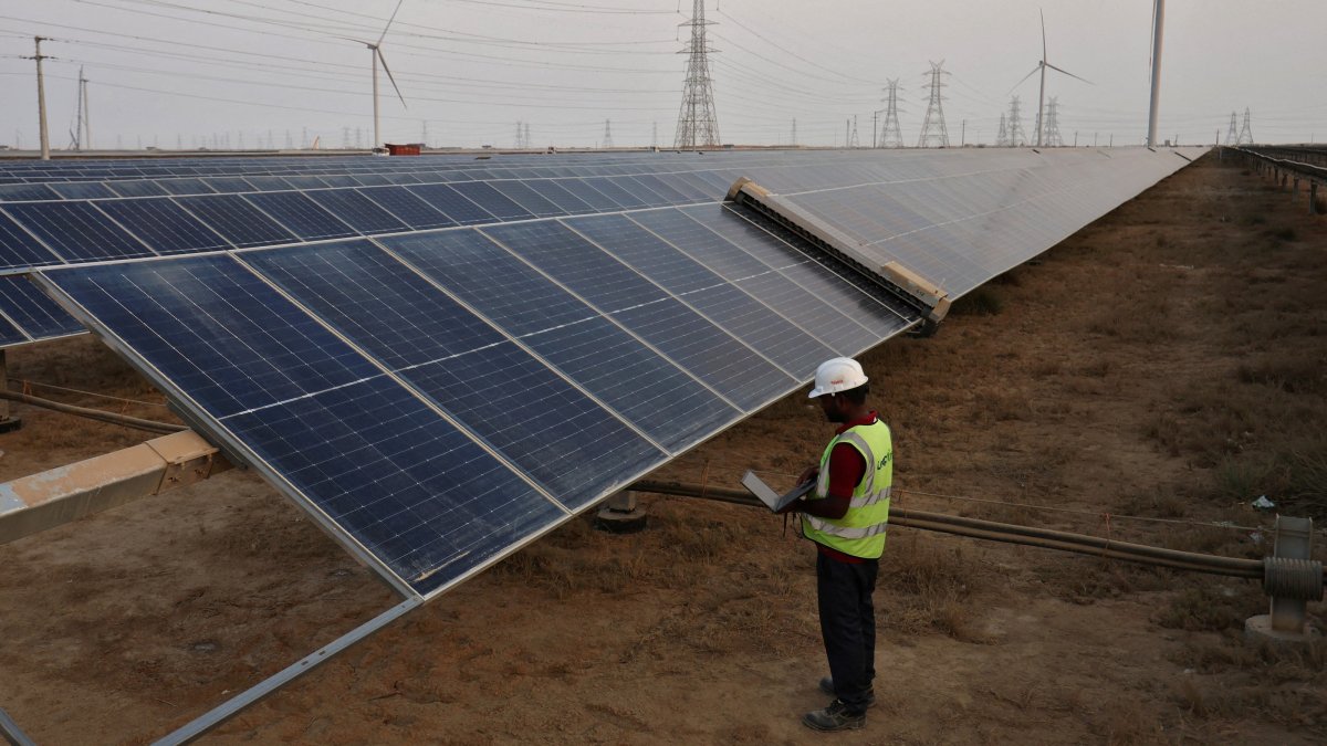 A technician checks the movement of an automated cleaning brush installed over solar panels, Khavda, India, April 12, 2024. (Reuters Photo)