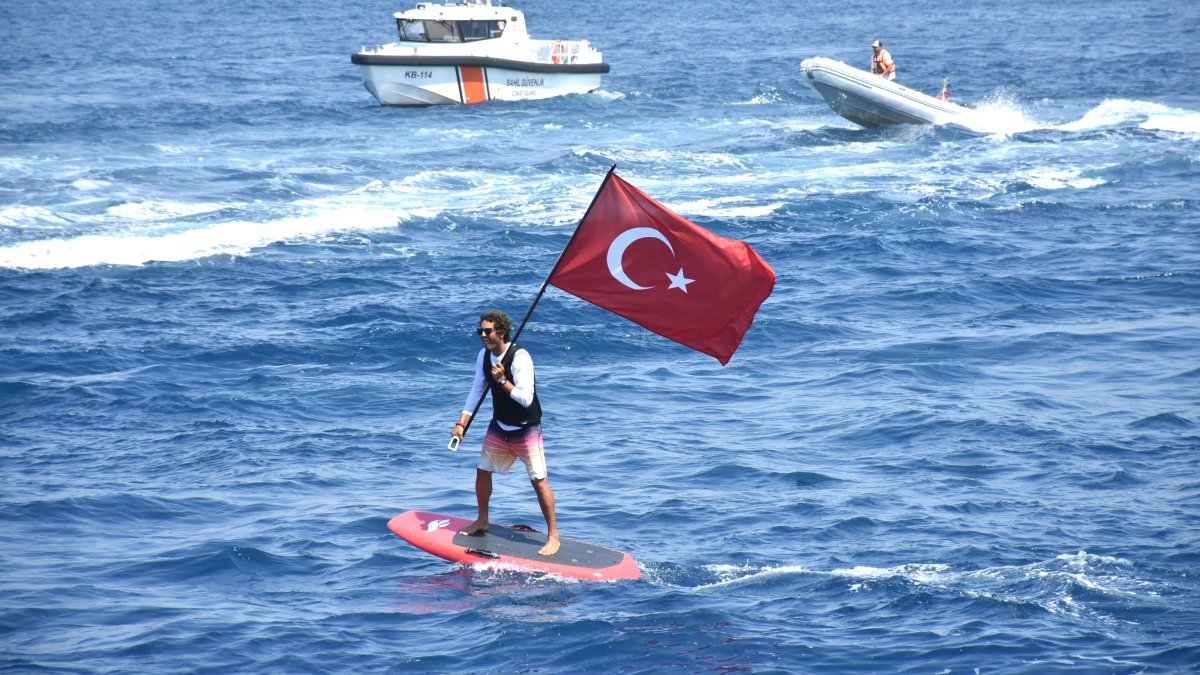 A man waves a Turkish flag while paddleboarding off the coast of Bodrum, southwestern Türkiye, July 1, 2025. (AA Photo)