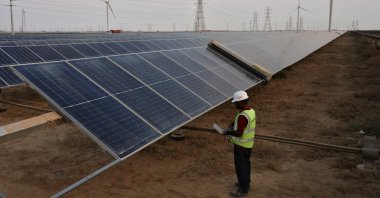 A technician checks the movement of an automated cleaning brush installed over solar panels, Khavda, India, April 12, 2024. (Reuters Photo)