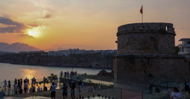 Visitors watch the sunset from the viewing terrace at the restored Hıdırlık Tower archaeological site, Antalya, Türkiye, July 21, 2026. (IHA Photo)