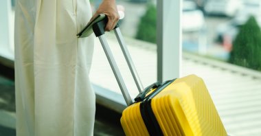 A woman carries her luggage during travel. (Shutterstock Photo)