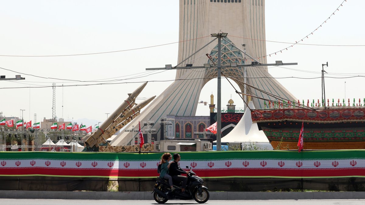 Two Iranians ride a motorbike next to a mock-up of the Zolfaghar missiles on display at Azadi Square in Tehran, Iran, July 24, 2026. (EPA Photo)
