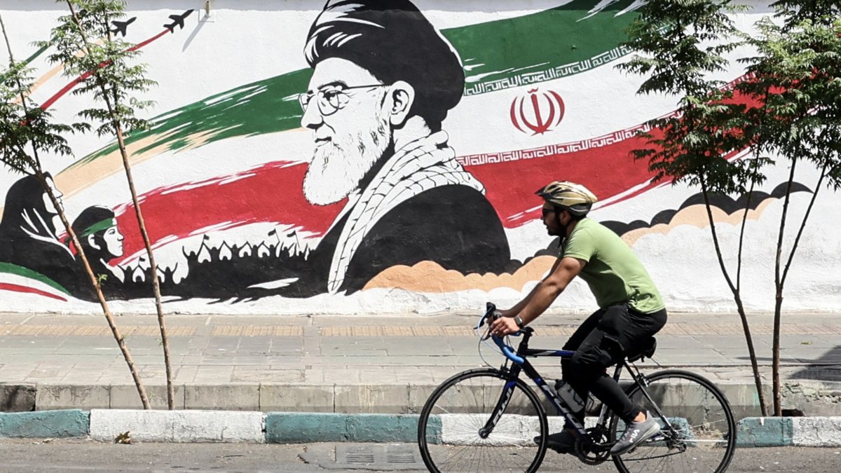 A man cycles past a mural depicting late Iranian Supreme Leader Ayatollah Ali Khamenei in Tehran, Iran, July 24, 2026. (AFP Photo)
