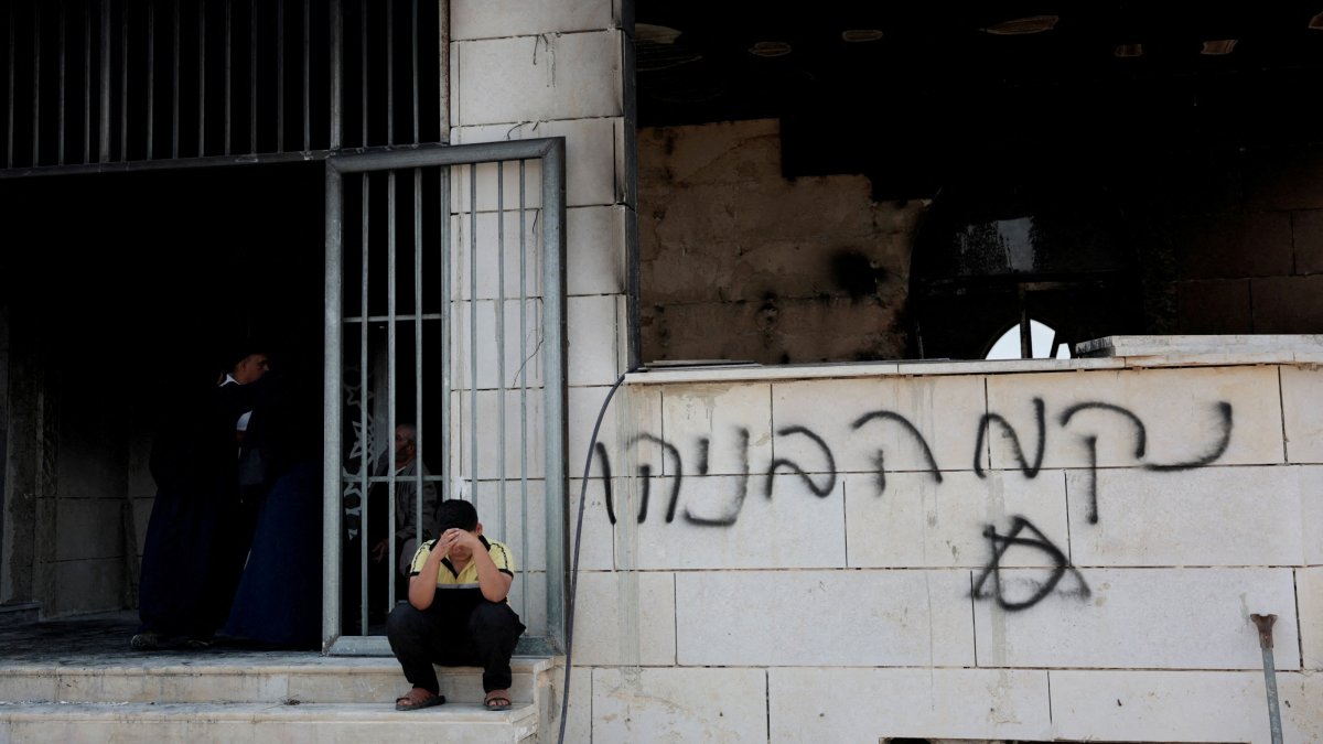 A Palestinian boy sits near a mosque torched by illegal Israeli settlers in Qusra near Nablus, in the Israeli-occupied West Bank, July 26, 2026. (Reuters Photo)