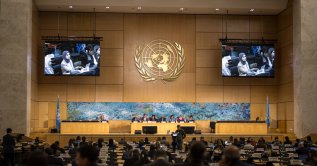 A representative of Qatar is seen on screens as he delivers a speech on human rights in the Islamic Republic of Iran during a session of the U.N. Human Rights Council, in Geneva, March 16, 2026. (AFP File Photo)
