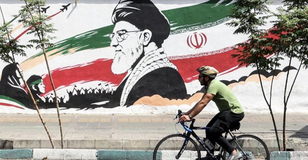 A man cycles past a mural depicting late Iranian Supreme Leader Ayatollah Ali Khamenei in Tehran, Iran, July 24, 2026. (AFP Photo)