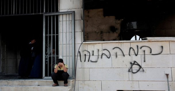 A Palestinian boy sits near a mosque torched by illegal Israeli settlers in Qusra near Nablus, in the Israeli-occupied West Bank, July 26, 2026. (Reuters Photo)