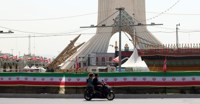 Two Iranians ride a motorbike next to a mock-up of the Zolfaghar missiles on display at Azadi Square in Tehran, Iran, July 24, 2026. (EPA Photo)