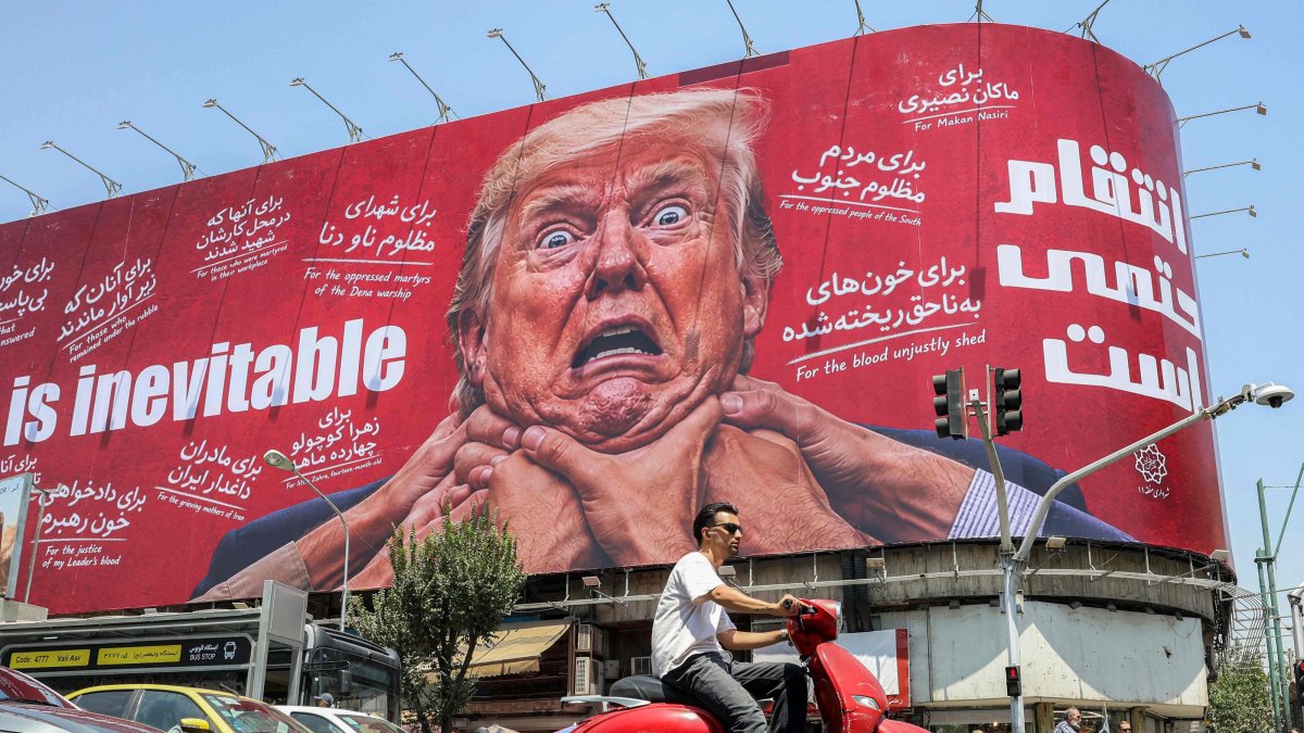Motorists drive past a large billboard pledging revenge against U.S. President Donald Trump along Jomhouri Street in central Tehran, July 27, 2026. (AFP Photo)