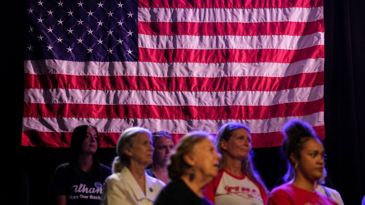 People in front of an American flag attend a campaign rally for Minnesota Lt. Gov. Peggy Flanagan, who is running against Angie Craig for the Democratic nomination to fill Tina Smith's Senate seat, in Minneapolis, Minnesota, U.S., July 20, 2026. (Reuters File Photo)
