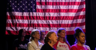 People in front of an American flag attend a campaign rally for Minnesota Lt. Gov. Peggy Flanagan, who is running against Angie Craig for the Democratic nomination to fill Tina Smith's Senate seat, in Minneapolis, Minnesota, U.S., July 20, 2026. (Reuters File Photo)