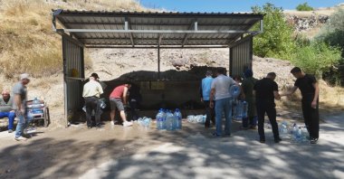 People line up around a fountain to fill up water cans amid water cuts, Ankara, Türkiye, July 27, 2026. (İHA Photo)