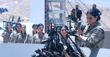 PKK members line up to put their weapons into a pit during a disarmament ceremony, Sulaimaniyah, northern Iraq, July 11, 2025. (AFP Photo)