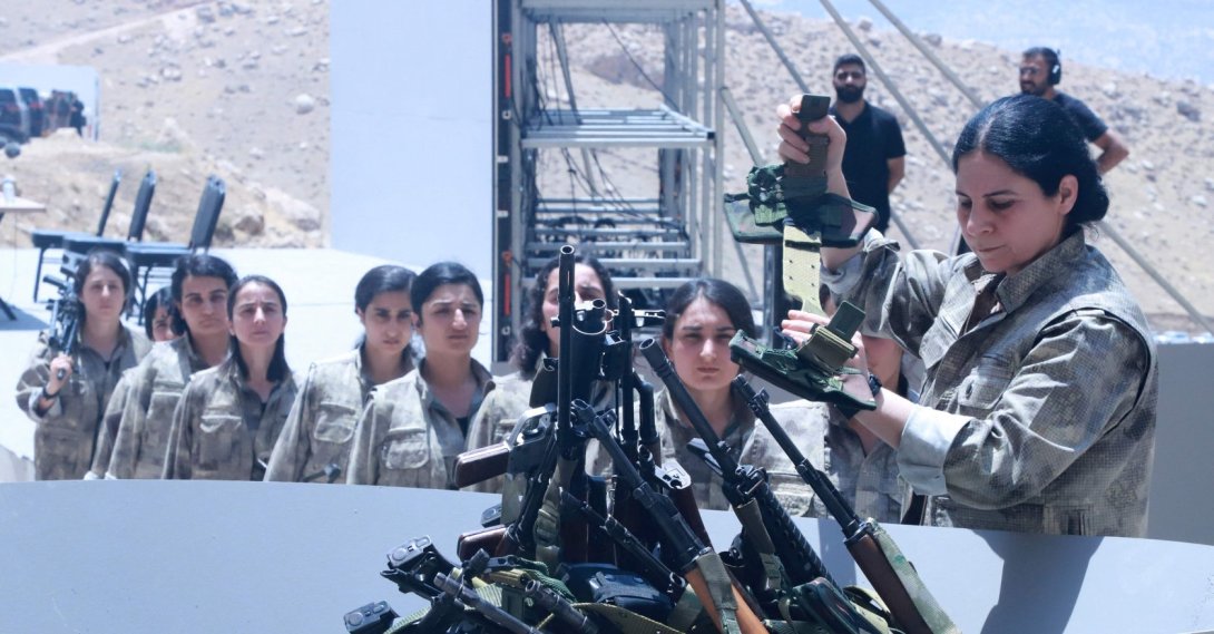 PKK members line up to put their weapons into a pit during a disarmament ceremony, Sulaimaniyah, northern Iraq, July 11, 2025. (AFP Photo)