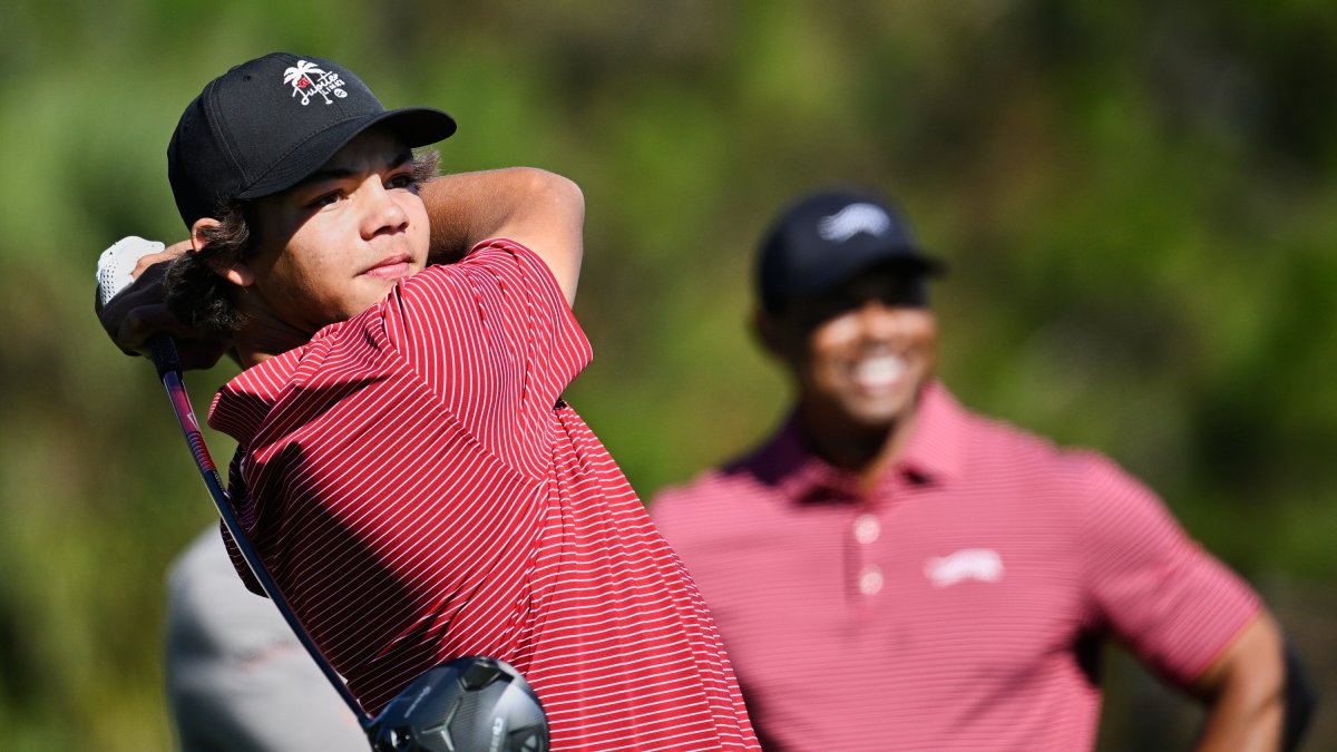 FILE- Charlie Woods tees off on the fifth hole as his father Tiger Woods watches during the final round of the PNC Championship golf tournament, Orlando, U.S., Dec. 22, 2024. (AP Photo)