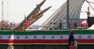 A woman and a child walk past Iranian-made Zolfaghar missiles displayed at Azadi Square in Tehran, Iran, July 24, 2026. (AFP Photo)