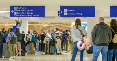 Airline passengers waiting for their luggage to arrive in the baggage claim area of the Louis Armstrong International Airport, New Orleans, U.S., March 16, 2026. (Shutterstock Photo)