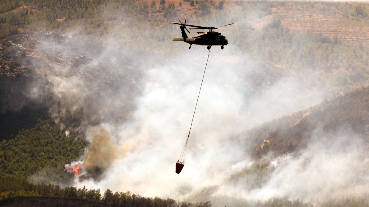 A helicopter battles a forest fire in the Alanya district of Antalya, Türkiye, July 30, 2026. (AA Photo)