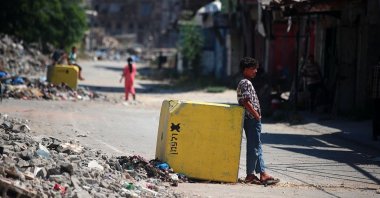 Palestinians walk past a concrete block marking the "Yellow Line" drawn by the Israeli military along Salah al-Din Street, Gaza, Palestine, July 27, 2026. (Getty Images Photo)