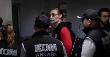 Police officers escort Erdal Beşikçioğlu after his detention, Ankara, Türkiye, July 30, 2026. (AA Photo)
