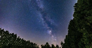 The Milky Way galaxy pictured arcing above the forest tree line in the Ardennes mountains, Chanxhe village, Belgium, July 20, 2026. (Getty Images Photo)