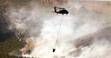 A helicopter battles a forest fire in the Alanya district of Antalya, Türkiye, July 30, 2026. (AA Photo)