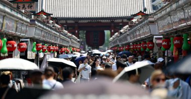 Visitors holding parasols walk along Nakamise Street at the Asakusa district, a popular sightseeing spot, as the Japanese government issued a heatstroke alert in Tokyo and other prefectures due to a heat wave, Tokyo, Japan, July 22, 2026. (Reuters Photo)