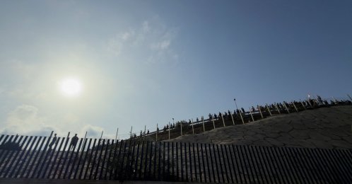 People gather near the border fence between the Spanish enclave of Ceuta and Morocco, hours after thousands of migrants crossed into Ceuta by sea, as seen from Ceuta, Spain, July 30, 2026. (Reuters Photo)